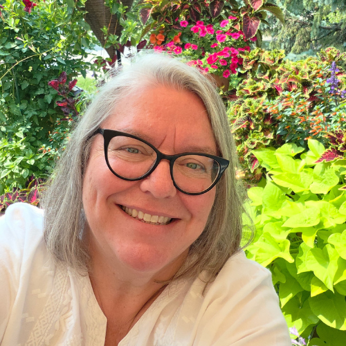 image of Patti, the store's General Manager, smiling, surrounded by flowers